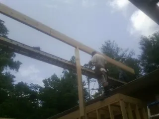 Carpenter setting a ridge beam over a new addition frame — Ice Dam Removal by Roofing Brothers in Fort Worth