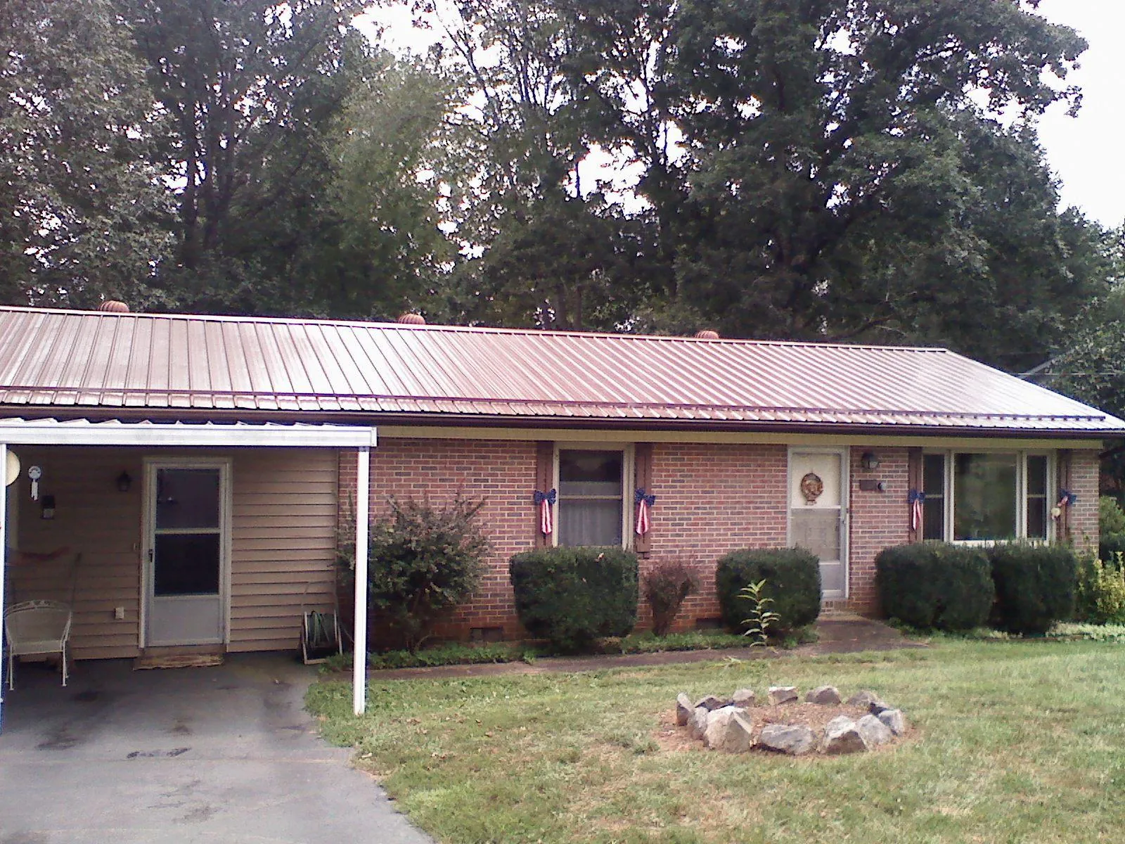 Bronze metal roof and carport on a brick ranch home — Roof Repair work by our crew in Fort Worth