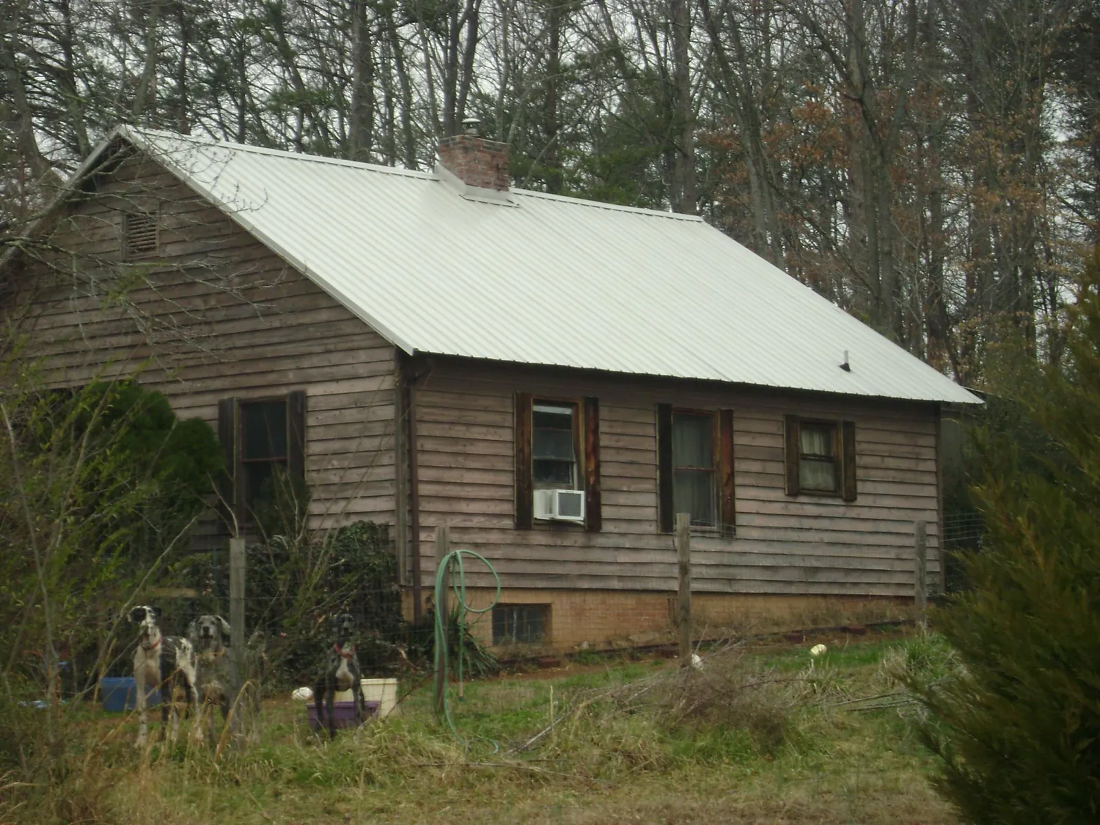 White metal roof on an old wood sided farmhouse, from a Metal Roof Installation job in Fort Worth